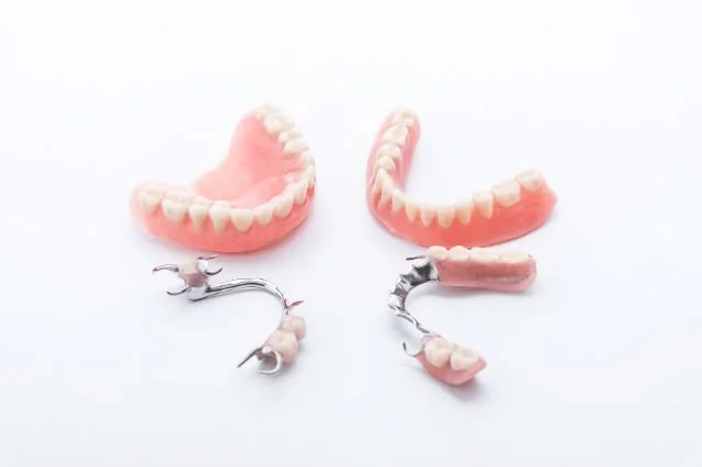 Prótesis dentales completas y parciales sobre fondo clínico